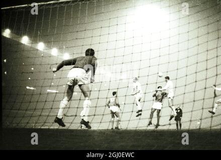 European Cup 3rd Round 1st leg Manchester United v Benfica Manchester United il portiere Gregg (a sinistra) salta in anticipo mentre Benfica Forward (camicie scure) fa una mossa attaccante durante la loro partita di prima tappa di terza manche della Coppa europea a Old Trafford. Altri giocatori identificati sono Bobby Charlton (a destra del No.10), Noel Cantwell, a sinistra indietro (andando la palla lontano da Benfica all'interno di destra Eusebio) e No.10 Benfica all'interno di sinistra Jose Augusto. 2 febbraio 1966. Foto Stock