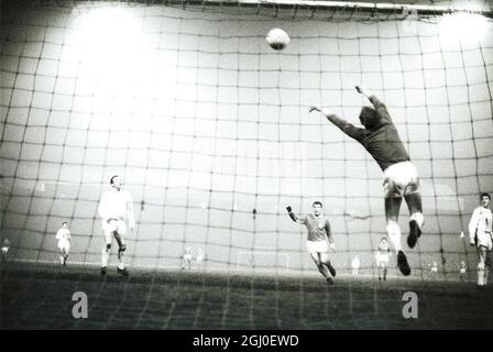 Coppa europea 3° turno 1° tappa Manchester United v Benfica Manchester United il portiere Harry Gregg (a destra) è raffigurato raggiungere per un alto pallone durante la Coppa europea terzo turno prima tappa partita contro Benfica a Old Trafford. Altri giocatori identificati sono Nobby Stiles, e Benfica fuori-sinistra Pedras. 2 febbraio 1966. Foto Stock