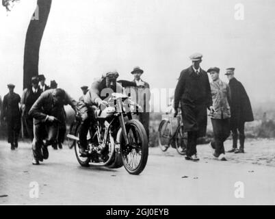 Il motociclista inglese Atkins farà un tentativo sul record mondiale motociclistico giovedì 18 ottobre a Bonheyden-lez-Malines in Belgio - la foto mostra Atkins sulla sua moto con il progettista della macchina ( centro ) 13 ottobre 1934 Foto Stock