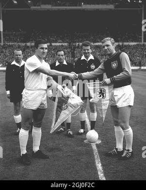 Rudi Brunnenmeier (a sinistra) capitano di Monaco 1860 scambia i pennant con il capitano del West Ham United Bobby Moore prima della finale della Coppa europea di Wembley. In background ci sono l'arbitro ungherese Istvan Zolt, assistito dai connazionali K.Schopp e G.Soss. 19 maggio 1965. Foto Stock