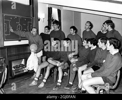 I giocatori dell'Arsenal guardano come l'allenatore Ernie Collett utilizza la nuova tavola per dimostrare le mosse, nello spogliatoio di Highbury. 30 marzo 1967. Foto Stock