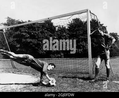 Il portiere del Chelsea Peter Bonetti fa un salvataggio spettacolare durante l'addestramento al Chelsea come Alex Stepney si alza e guarda. 17 agosto 1966. Foto Stock