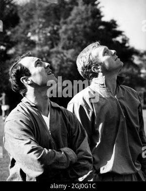 I giocatori inglesi, Jimmy Greaves (a sinistra) e Bobby Moore (a destra), sono distratti da un aereo durante la loro sessione di allenamento a Roehampton, Surrey. Si stanno sfidando il resto del mondo a Wembley il 23 ottobre 1963. 22 ottobre 1963 Foto Stock