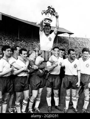 1958 fa Cup Final Manchester United contro Bolton Wanderers Nat Lofthouse, il Bolton Center-Forward e capitano, che ha segnato entrambi i gol del suo fianco è presieduto fuori dal campo, mentre, tenendo il trofeo fa Cup. 3 maggio 1958 Foto Stock