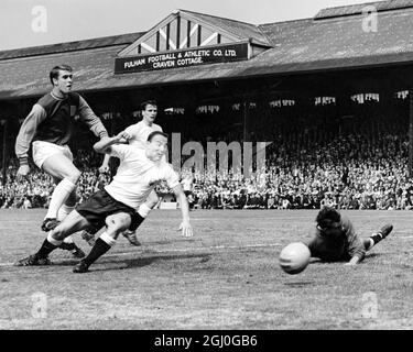 Fulham contro West Ham United Tony Macedo, portiere di Fulham, assistito dal suo dietro a destra George Cohen, allena questo attacco West Ham da parte di dentro-sinistra, Geoff Hurst. 22 agosto 1964 Foto Stock