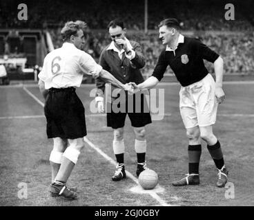 Inghilterra / Scozia Billy Wright (capitano inglese) a sinistra, scuotendo le mani con G.L Young (capitano scozzese) a destra, mentre l'arbitro G. Mitchell (Scozia) guarda avanti. 14 aprile 1951 Foto Stock