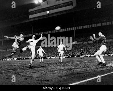 1962 Coppa europea semifinale seconda tappa Benfica contro Tottenham Hotspur Benfica centro-avanti, Aguas (sinistra) spara in direzione di Norman (seconda a sinistra) di Spurs, mentre Brown, Spurs portiere si prepara a salvare durante la partita a White Hart Lane. Sullo sfondo ci sono Blanchflower e Baker of Spurs. 5 aprile 1962 Foto Stock