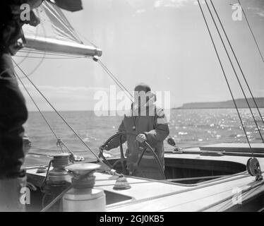 Weymouth, Dorset: Peter Scott al timone Sovereign di Weymouth Bay, Dorset ieri, come potenziale sfidante per la serie 1964 o America's Cup corse ha continuato le sue prove contro Scepter. Nella corsa di ieri, Scepter ha battuto Sovereign da una testa molto corta. All'inizio di maggio, Sovereign avrà una serie di prove contro il secondo possibile sfidante, Kurrewa V., che è stato lanciato da uno Scottish Builder's Yard durante il fine settimana. 14 aprile 1964 Foto Stock