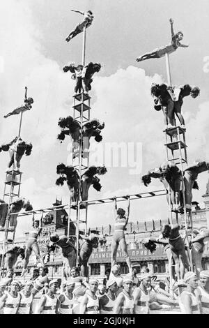 Più di 40,000 atleti delle undici repubbliche che costituiscono l'Unione Sovietica si sono sfilati trionfalmente attraverso la Piazza Rossa, Mosca, per celebrare il 20° anniversario della Rivoluzione. I membri delle ragazze della Dynamo Sports Society di Mosca formano piramidi mentre vengono trasportati attraverso la Piazza Rossa da giovani atleti maschi. 1937 Foto Stock