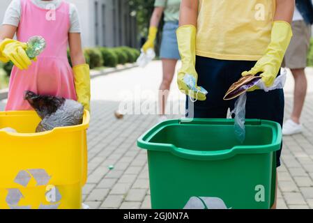 I bambini che ordinano la spazzatura vicino al cestino in cucina Foto stock  - Alamy