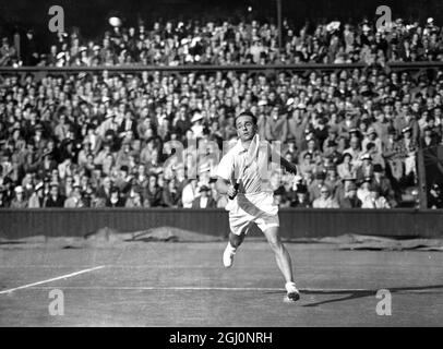 Fred Perry incontrò Adrian Quist in Australia nei singoli del Davis Cup Challenge legato tra Inghilterra e Australia a Wimbledon , Inghilterra . La pioggia ha fermato il gioco più volte . La foto mostra Quist scattando un colpo basso durante la partita . 25 luglio 1936 Foto Stock