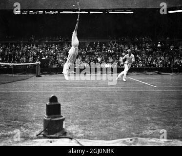 Donald Budge e gene Mako , gli americani che sono il campione di Wimbledon , hanno preso i primi due set 6-3 7-5 da Raymond Tuckey e Frank Wilde nei doppi del Davis Cup Challenge Round a Wimbledon , Inghilterra . Visto qui Budge salpata per una palla alta 26 luglio 1937 Foto Stock