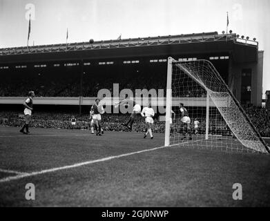 Ian McKechnie, portiere dell'Arsenal, è catturato in una posizione insolita mentre ha punzonato chiaro durante la partita contro il Manchester United ad Highbury . In maglia bianca è Scottish International e Manchester United Inside-left Denis Law . 21 settembre 1963 Foto Stock