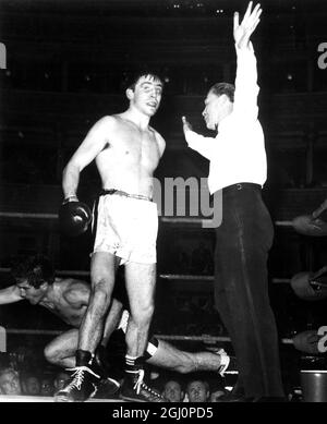 Jimmy Tibbs si gira mentre l'arbitro Bill Williams ferma la lotta nell'ultimo round di Tibbs 8 round internazionale di pesi leggeri contro Franco Macchia di Roma , che si vede scendere per la seconda volta al Royal Albert Hall di Londra il 7 marzo 1967 Foto Stock