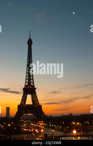 La Torre Eiffel Twoer a Parigi all'alba del mattino presto con il sole che sorge all'orizzonte, cielo azzurro pallido alcune nuvole bianche e la luce del sole giallo dorato se Foto Stock