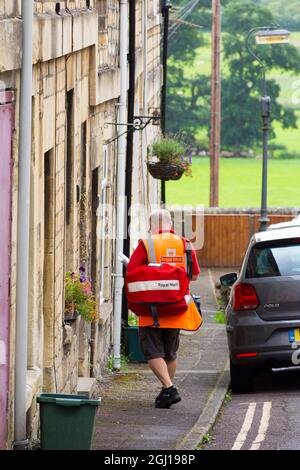 Royal Mail Postman sul suo turno di consegna, Batheaston, Bath, Inghilterra, Regno Unito Foto Stock