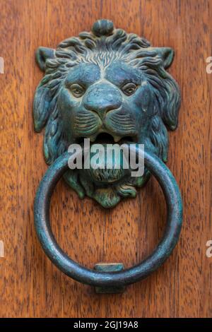 Italia, Sicilia, Provincia Di Messina, Caronia. Una porta in bronzo bussa a forma di leone, nella città medievale di Caronia. Foto Stock