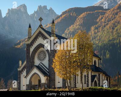 Chiesa di San Sebastiano a Falcade in Val Biois, sullo sfondo la catena montuosa Focobon, pale di San Martino, Italia. Foto Stock