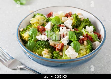 insalata di broccoli sana con formaggio feta pomodori secchi pinoli. vegetariano basso keto carb dieta Foto Stock