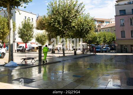 Valence, Francia - 09 04 2021 : un uomo pulisce una piazza dopo un mercato. Foto Stock