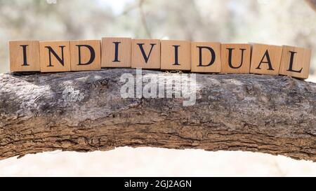 La parola individuale è stata creata da blocchi di legno. Sociologia e vita. Primo piano Foto Stock