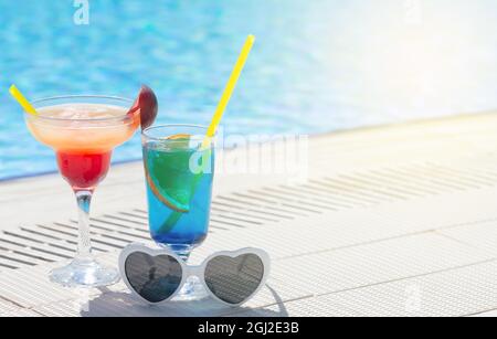 Due colorati bicchieri da cocktail ai bordi della piscina. Con spazio per la copia Foto Stock