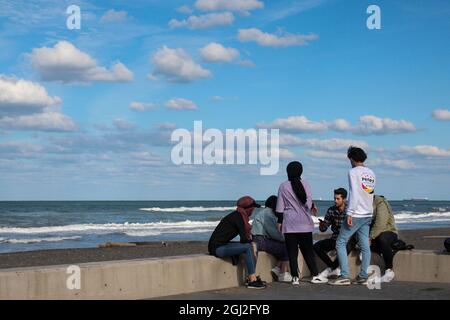 Persone etniche miste al mare che hanno conversazioni. Decisioni sulla vita. Ulteriori piani di vita. Foto Stock