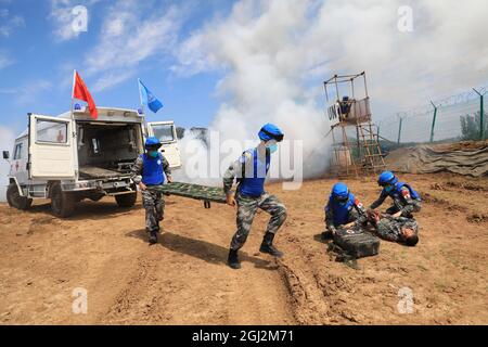 (210908) -- ZHENGZHOU, 8 settembre 2021 (Xinhua) -- i peacekeepers partecipano ad un'esercitazione internazionale di peacekeeping ad una base di addestramento tattico delle armi combinate dell'Esercito popolare di liberazione cinese (PLA) nella provincia centrale di Henan della Cina, 8 settembre 2021. La Cina ha iniziato a tenere un trivello internazionale per il mantenimento della pace denominato in codice 'Shaved Destiny-2021' il 6 settembre. Sono in corso esercitazioni di ricognizione sul campo di battaglia, sorveglianza e pattugliamento della sicurezza, scorta armata, protezione dei civili, risposta agli attacchi violenti e terroristici, costruzione di una base operativa temporanea, pronto soccorso sul campo di battaglia e controllo pandemico Foto Stock