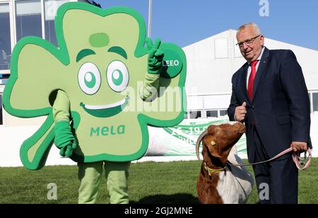 08 settembre 2021, Meclemburgo-Pomerania occidentale, Mühlengeez: Alla conferenza stampa per presentare il programma della 30a fiera agricola Mela, fino a Backhaus (SPD), Ministro dell'Agricoltura di Meclemburgo-Pomerania occidentale, si trova accanto alla mascotte Kleeo e con Boer capra Linda, l'animale di Mela 2021. Dopo una pausa di un anno da Corona, la più grande fiera agricola di Meclemburgo-Pomerania occidentale ricomincia dal 16.09.2021. Foto: Bernd Wüstneck/dpa-Zentralbild/dpa Foto Stock