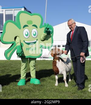 08 settembre 2021, Meclemburgo-Pomerania occidentale, Mühlengeez: Alla conferenza stampa per presentare il programma della 30a fiera agricola Mela, fino a Backhaus (SPD), Ministro dell'Agricoltura di Meclemburgo-Pomerania occidentale, si trova accanto alla mascotte Kleeo e con Boer capra Linda, l'animale di Mela 2021. Dopo una pausa di un anno da Corona, la più grande fiera agricola di Meclemburgo-Pomerania occidentale ricomincia dal 16.09.2021. Foto: Bernd Wüstneck/dpa-Zentralbild/dpa Foto Stock