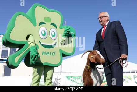 08 settembre 2021, Meclemburgo-Pomerania occidentale, Mühlengeez: Alla conferenza stampa per presentare il programma della 30a fiera agricola Mela, fino a Backhaus (SPD), Ministro dell'Agricoltura di Meclemburgo-Pomerania occidentale, si trova accanto alla mascotte Kleeo e con Boer capra Linda, l'animale di Mela 2021. Dopo una pausa di un anno da Corona, la più grande fiera agricola di Meclemburgo-Pomerania occidentale ricomincia dal 16.09.2021. Foto: Bernd Wüstneck/dpa-Zentralbild/dpa Foto Stock