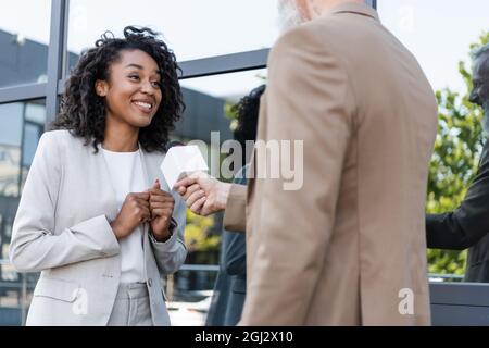 reporter con microfono fare reportage con felice afro americano donna d'affari Foto Stock