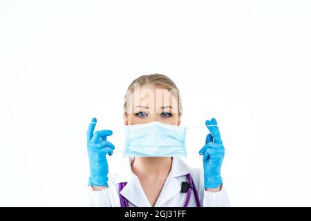 Donna che indossa una maschera di protezione antivirus per prevenire altre infezioni da corona COVID-19 e SARS COV 2. La donna mette su un medico protettivo Foto Stock