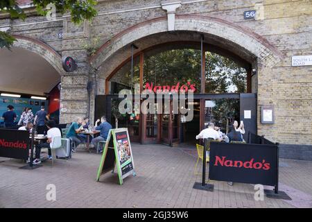 Nandos UK; ristorante Nandos con persone che mangiano fuori, Vauxhall, Londra UK Foto Stock