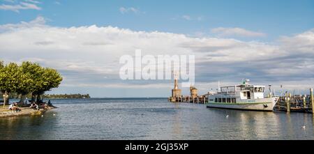 L'ingresso del porto con la nave da visita che si trova in banchina a Costanza, Baden-Württemberg, Deutschland, in background Imperia e faro Foto Stock