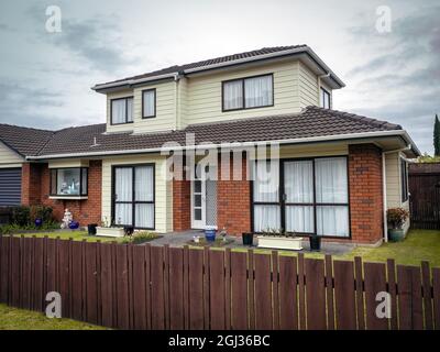 AUCKLAND, NUOVA ZELANDA - 07 luglio 2021: Una tipica casa suburbana con tetto in piastrelle e recinzione in legno a Auckland, Nuova Zelanda Foto Stock
