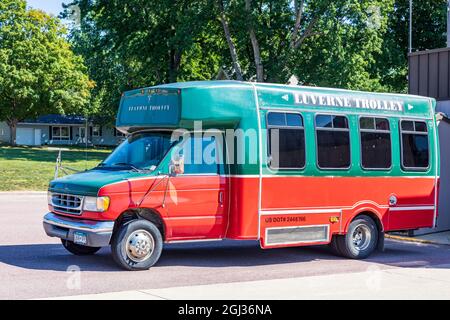 LUVERNE, MN, USA-21 AGOSTO 2021: Il Trolley Luverne, un piccolo autobus su un telaio furgone dipinto di arancione e verde brillante. Foto Stock
