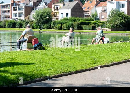 Wemmel, Regione fiamminga - Belgio - 09 01 2021: Tre vecchi pescatori in un lago locale Foto Stock