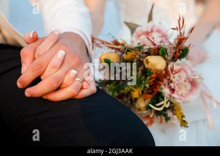 Sposare e sposare insieme, e tenere le mani e Sposa tenere il suo bouquet di nozze . Concetto di matrimonio. Foto di alta qualità Foto Stock