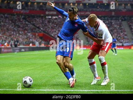 Jack Grealish (a sinistra) e Kamil Glik in Polonia lottano per la palla durante la partita di qualificazione della Coppa del mondo FIFA 2022 al PGE Narodowy Stadium di Varsavia. Data foto: Mercoledì 8 settembre 2021. Foto Stock