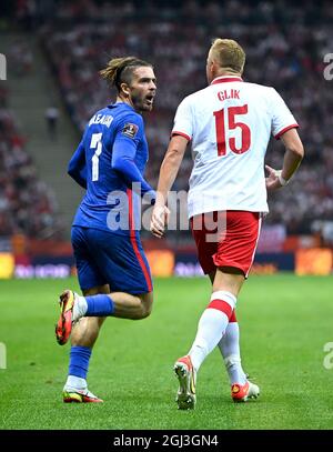 L'inglese Jack Grealish (a sinistra) parla con Kamil Glik in Polonia durante la partita di qualificazione della Coppa del mondo FIFA 2022 al PGE Narodowy Stadium di Varsavia. Data foto: Mercoledì 8 settembre 2021. Foto Stock