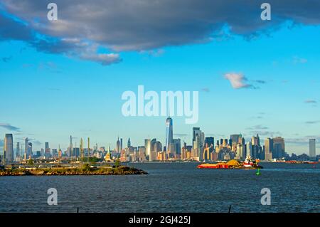 Vista dello skyline dell'isola di Manhattan di New York City, tra cui la Freedom Tower, l'Empire state Building e la Statua della libertà, in una giornata di sole -01 Foto Stock