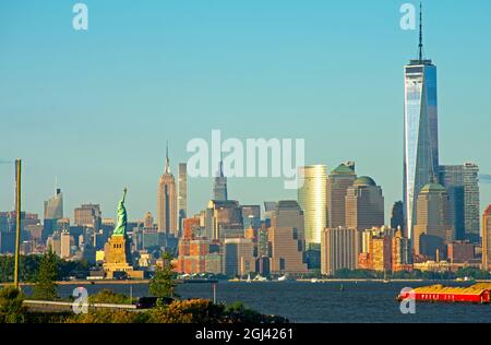 Vista dello skyline dell'isola di Manhattan di New York City, tra cui la Freedom Tower, l'Empire state Building e la Statua della libertà, in una giornata di sole -02 Foto Stock