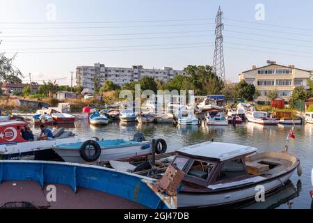 Piccole barche da pesca su un torrente tra la costa del Mar di Marmara e il lago di Kucukcekmece al punto di ingresso nel sud del canale di Istanbul, Turchia. Foto Stock