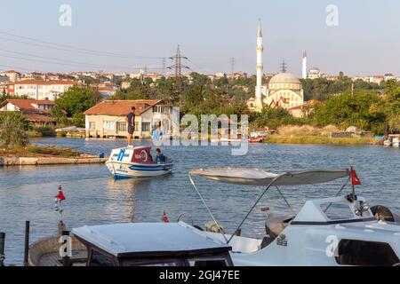 Piccole barche da pesca su un torrente tra la costa del Mar di Marmara e il lago di Kucukcekmece al punto di ingresso nel sud del canale di Istanbul, Turchia. Foto Stock