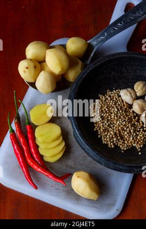Shot verticale ad alto angolo di ingredienti sotto forma di peperoncini e patate Foto Stock
