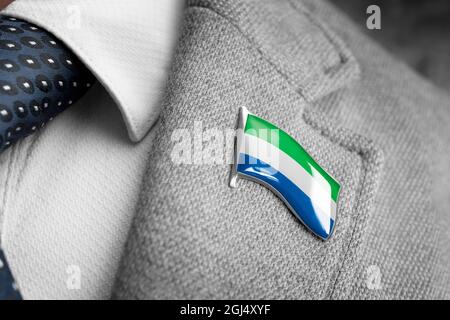 Distintivo in metallo con la bandiera della Sierra Leone su un lapel tuta Foto Stock