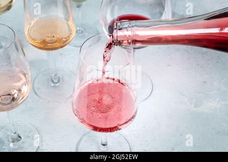 Vino rosato versato in un bicchiere durante una degustazione in una cantina, con spazio copia. Evento di degustazione vini Foto Stock