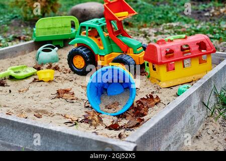 Giocattoli dimenticati nel sandbox esterno. Parco giochi per bambini all'aperto Foto Stock