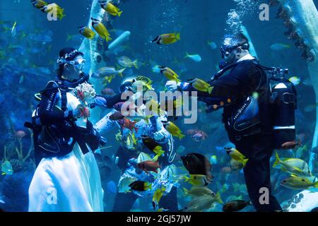 Lo sposo Chris Jackson si prepara a scambiare gli anelli di nozze con la sposa Lisa Huggins durante la loro cerimonia nuziale subacquea all'avventura di Grylls del Bear, Birmingham. I fan delle immersioni erano dovuti sposarsi all'estero ma i loro piani erano scupati durante Covid, e cercavano un'alternativa unica. Data foto: Mercoledì 8 settembre 2021. Foto Stock